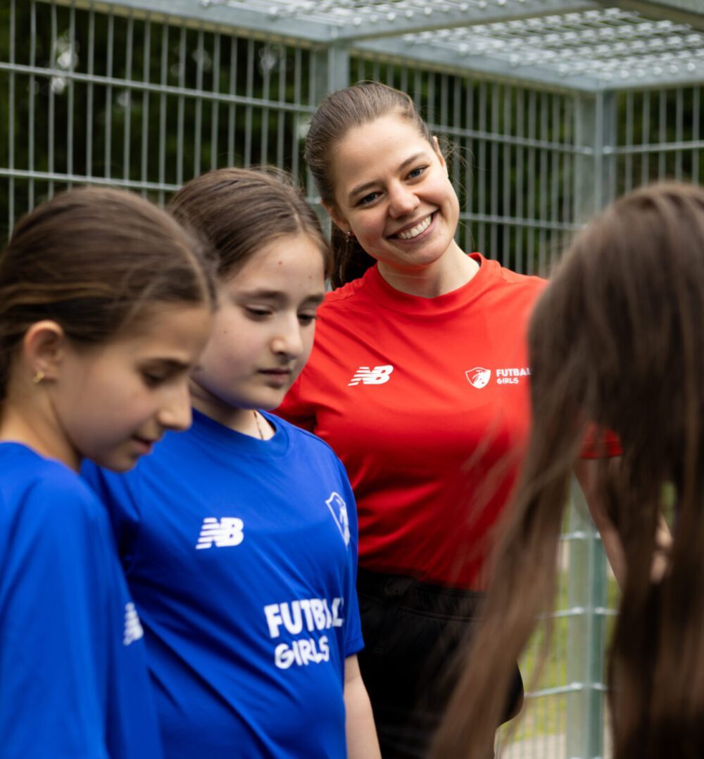 Head Coach mit Mädchen Head Coach lacht mit Mädchen beim Training